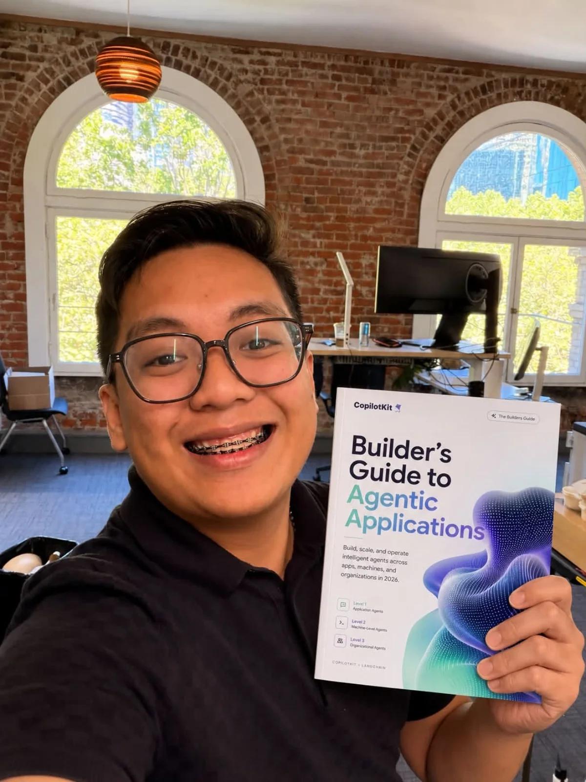 Jerel Velarde holding the Builder's Guide to Agentic Applications